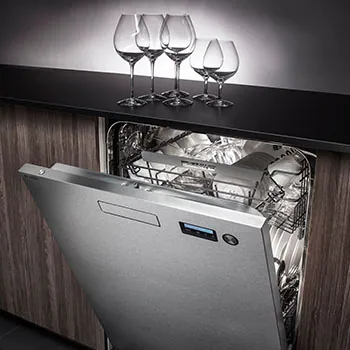 Half-open dishwasher with wine glasses on top