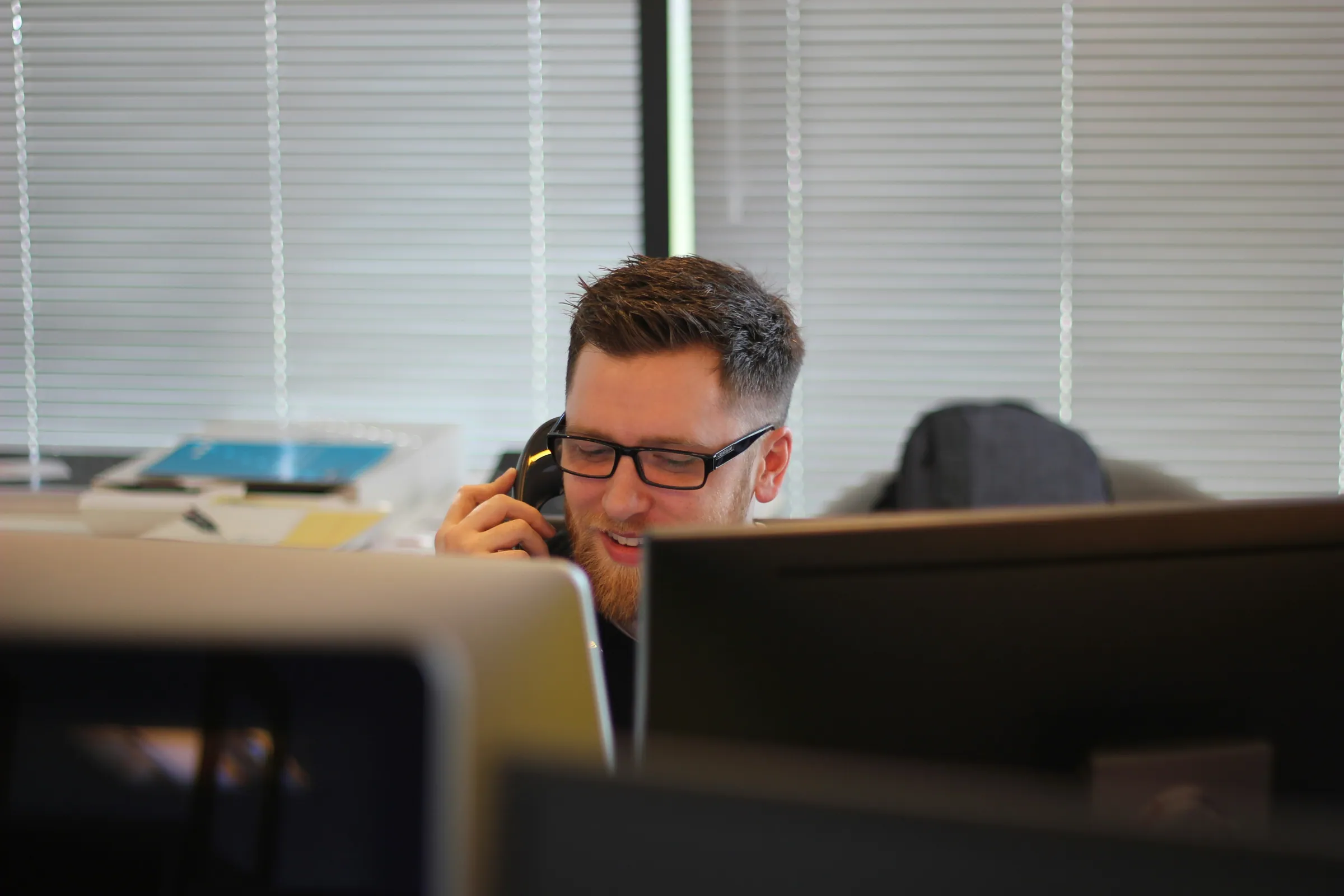 Customer service employee on the phone at his desk